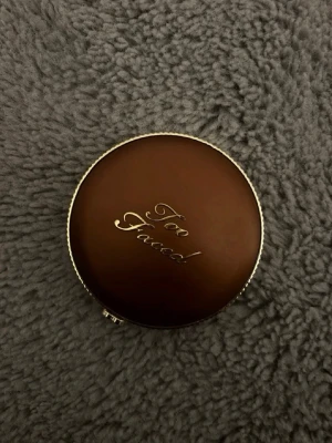 Too Faced Chocolate powder Bronzer - Snygg bronzer från Too Faced i nyansen Chocolate Matte. Kommer i en rund, brun och guldig dosa med spegel. Pudret har en matt finish och är perfekt för att skapa en solkysst look eller för contouring.