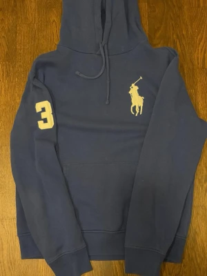  Ralph lauren hoodie  - En mörkblå Ralph lauren hoodie med den stora Ralph lauren loggan. Skick 7/10. Priset är ej hugget i sten! 