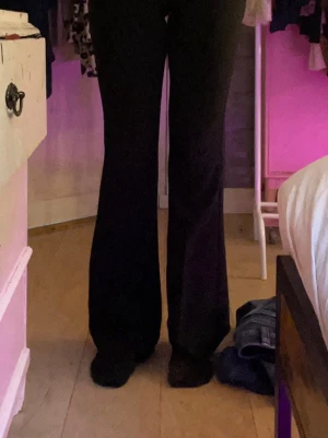 Svarta utsvängda kostymbyxor  - Säljer ett par svarta kostymbyxor med utsvängda ben. De har hög midja och är i ett stretchigt material som sitter bekvämt. Perfekta till en avslappnad stil eller att matcha med en oversized tröja.