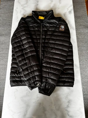 Svart dunjacka från Parajumpers - Säljer en svart dunjacka från Parajumpers. Den har 2 hål vid handleden och 2 små hål precis bredvid vänster ficka.