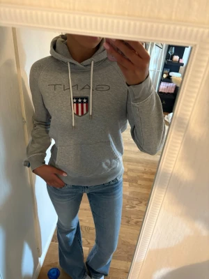Grå Gant hoodie  - Grå gant hoodie som knappt är använd. Mjukt och gosigt material innuti. Perfekt att använda till kyligare sommarkvällar eller regniga höst dagar