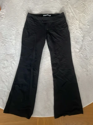 Svarta utsvängda leggings - Snygga svarta leggings med utsvängda ben och hög midja. De är stretchiga och sitter bekvämt, perfekta till en avslappnad stil. Materialet är mjukt och följsamt, vilket gör dem lätta att röra sig i.