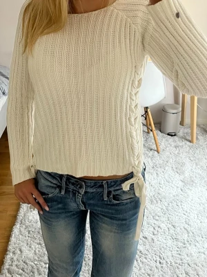 Vit stickad tröja med flätad detalj - Säljer en snygg tröja med flätade detaljer på båda sidorna💕