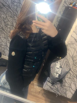 Svart dunväst från Moncler skriv för mer information  - Fins några skador på dne men skriv så skickar jag bild på dem,Snygg svart dunväst från Moncler med quiltad design och dragkedja framtill. Västen har en klassisk, kroppsnära passform och Moncler-logga på bröstet. Perfekt att styla över en hoodie eller långärmad tröja för en trendig look.