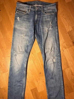 Ljusblå slitna jeans Calvin Klein - Säljer ett par ljusblå jeans från Calvin Klein med snygga slitningar på både fram- och baksida. Skön färg på jeansen💯. Toppskick!🔝