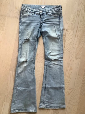 Ljusblå bootcut jeans med broderade fickor - Super populära low waist jeans från Gina med broderade fickor. Storlek M 
