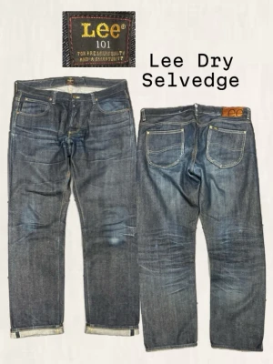 Lee 101 Dry Selvedge jeans - Säljer ett par mörkblå Lee 101 Dry Selvedge jeans i klassisk rak modell. Jeansen har tydliga selvedge-detaljer vid benslut, fem fickor och guldfärgade sömmar. Tillverkade i rå denim för en schysst och slitstark look.