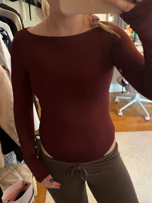 Vinröd långärmad body - Snygg vinröd body med långa ärmar och rund halsringning. Tillverkad i ett stretchigt och mjukt material som sitter tight mot kroppen. Perfekt att styla med jeans eller kjol för en clean look. Skriv pm vid funderingar!☺️