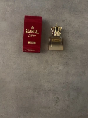 Scandal Absolu Eau de Parfum - Scandal Absolu Eau de Parfum från Jean Paul Gaultier. Den är helt fylld Flaskan är fyrkantig i glas med en guldig krona som lock och etikett framtill. Förpackningen är mörkröd med guldiga detaljer och logga. En lyxig och elegant parfym som sticker ut i badrumshyllan.