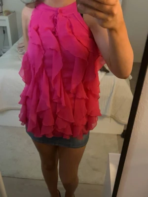 rosa volang topp - Supersöt rosa volang blus.Väldigt unik och vacker!! använd 1 gång men säljer den för den inte kommer till användning 