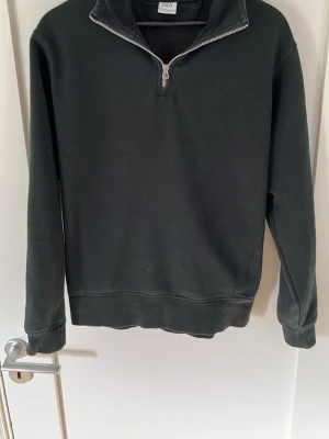 Svart halvzip tröja från ZARA - En svart långärmad tröja från ZARA med halvzip och hög krage. Tillverkad i mjukt material som känns skönt mot huden. Perfekt för lager på lager och enkel att matcha med olika outfits.