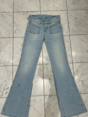 Ljusblå bootcut jeans från Diesel - Diesel jeans – ljusblå  Säljer ett par ljusblå Diesel-jeans som är knappt använda och i mycket fint skick. Det finns en mindre blå fläck på ena benet (se bild), annars är jeansen i toppskick.  
