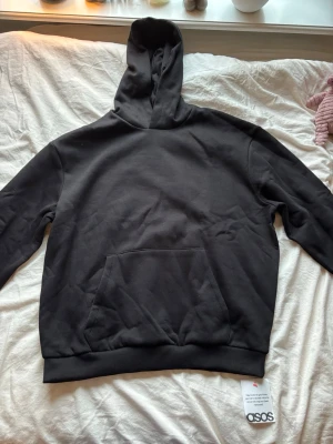 Svart hoodie från ASOS DESIGN - Svart hoodie från ASOS DESIGN i storlek M. Tröjan är helt ny och aldrig använd med prislapp kvar! Ordinarie pris är 349 kr.