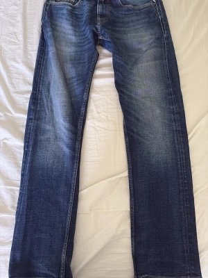 Mörkblå raka jeans med slitningar - Snygga mörkblå jeans med raka ben och diskreta slitningar framtill. Jeansen har klassisk femficksdesign och kontrastsömmar. Materialet är denim i bomull och passformen är relaxed fit. Perfekta för en avslappnad och trendig look. Model Rocco