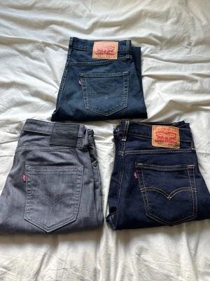 3x Levi’s 511 Jeans – Blå & Grå – Storlek W31 L34 - Säljer 3 par Levi’s 511 jeans i fint skick. Två par i mörkblå och ett par i grå färg. Alla är modell 511, en stilren och smal passform som passar både till vardag och fest.                Gråas storlek: W32 L34                                      Båda blåas storlek: W31 L34.                             1 par för 599  2 par för 999  3 för 1399