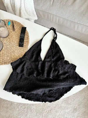 super snyggt tie around neck volang topp - säljer denna jätte snygga svarta topp som man knyter runt nacken. taggen har jag klippt bort men den är från Nelly i storlek L