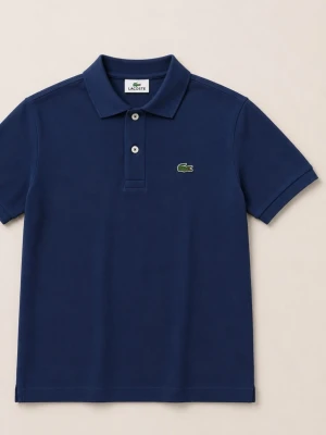 Marinblå pikétröja från Lacoste - Klassisk marinblå pikétröja från Lacoste med korta ärmar och krage. Tröjan har två knappar framtill och den ikoniska gröna krokodilloggan på bröstet. Tillverkad i mjuk bomull som känns skön mot huden.