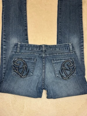 Lågmidjade bootcut jeans  - Ett par skit snygga lågmidjade bootcut jeans med detaljer på fickorna! Väldigt fint skick och sitter snyggt på! Kan skicka mått privat💕