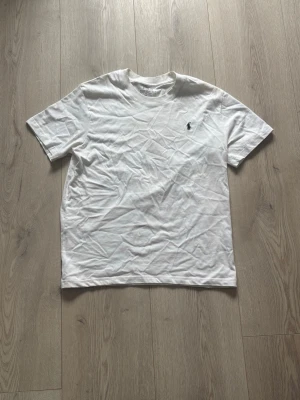 Vit Polo Ralph Lauren T-Shirt -  vit t-shirt från polo Ralph lauren slim fit. Använd bara ca 5 gånger. Sitter lite stort på mig är 176 väger 56.