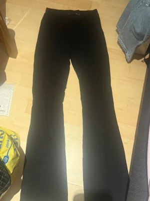 Svarta utsvängda leggings XS - Säljer ett par svarta leggings i storlek XS med utsvängda ben. De har en hög midja och är tillverkade i ett stretchigt material som sitter skönt på kroppen. Perfekta till en avslappnad look eller att styla med en oversized tröja.