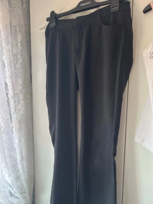 Svarta kostymbyxor från Gina tricot med raka ben - Snygga svarta kostymbyxor med raka ben och låg midja. Perfekta till en dressad outfit och passar till många olika stilar. De är andvända men har ett mycket fint skick. Färgen på knapparna där bak har dock slitits bort något, men ingen man tänker på enligt mig🥰Tvättas givetvis innan frakt🩷 Pris kan diskuteras