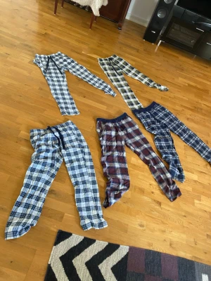 Rutiga pyjamasbyxor från Kappahl - Säljer flera par rutiga pyjamasbyxor från Kappahl i olika färger som blå, röd och beige. Byxorna har resår i midjan och snörning för bästa passform. Perfekta för mysiga hemmakvällar och tillverkade i mjukt bomullstyg.                         .                         .                               100kr styck eller alla för 300!!!