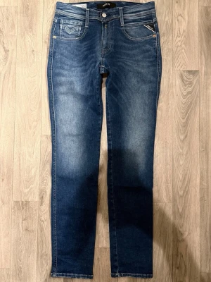 Replay Anbass Hyperflex Jeans Blå W29/L32 - Slim Fit - Replay Anbass Hyperflex blå jeans i stretchig Hyperflex denim med slim fit passform som sitter snyggt och bekvämt och funkar till allt, storlek W29/L32, midja 38 cm, ytterbenslängd 103 cm, benöppning 15,5 cm, modellen är 185cm & väger 65kg, i fint skick.