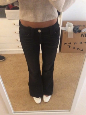 Svarta flare jeans med låg midja - Säljer ett par skit snygga low waist svarta flare jeans med mönster på bakfickorna.❤️
