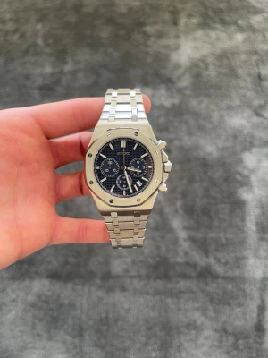 Seiko Mod Royal Oak-inspirerad – Blå Tavla - ✨ Specifikationer Modell: Seiko Mod Royal Oak-inspirerad Urverk: Automatiskt Seiko-urverk Boett: Rostfritt stål med kantad bezel Storlek: 41 mm 📏 Glas: Reptåligt safirglas 💎 Urtavla: Blå strukturerad tavla med subdials ⚙️
