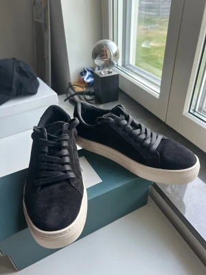 Svarta Vagabond stl 40 - Ett par svarta vagabond sneakers i mocka med vit sula. Storlek 40. Ej använda sen de köptes i nytt skick.