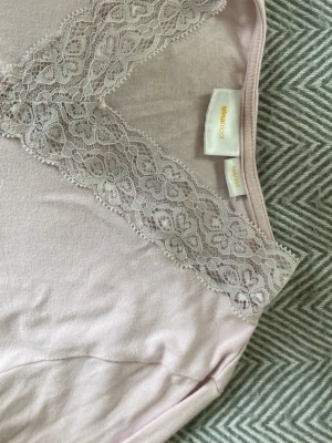 Ljusrosa långärmad topp med spets - Söt ljusrosa långärmad topp frpn Gina tricot. v-ringning dekorerad med spetsdetaljer. Tillverkad i mjukt material som känns skönt mot huden.
