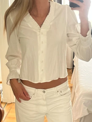 Söt vit blus - Jättesnygg vit blus med v-ringad hals och volangkant. Lite kortare. Lappen är inte kvar men uppskattar den vara strl XS. Väl omhändertagen❣️