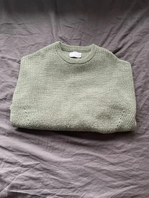 Grön stickad tröja  - Säljer en oversize grön stickad tröja med grov ribbstickning och rund hals. Tröjan har en loose passform och ganska långa ärmar. Tröjan är väldigt tjock och varm. Inga defekter