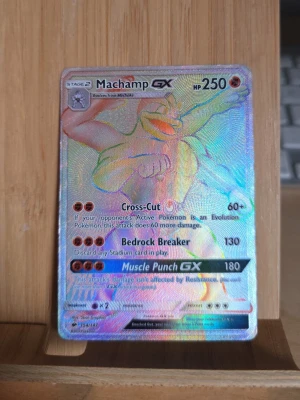 Machamp GX Pokémonkort holo - Machamp GX holografiskt Pokémonkort med färgstark och glansig yta. Kortet har attacker som Cross-Cut, Bedrock Breaker och Muscle Punch GX. Perfekt för samlare eller Pokémonfans som vill utöka sin kortlek.