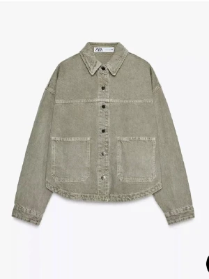 Grå jeansjacka från Zara - Grön jeansjacka från Zara. Jackan har två stora fickor framtill, klassisk krage och knäppning med metallknappar. Perfekt att slänga över en hoodie eller t-shirt.