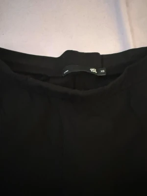 Svarta utsvängda leggings XS - Säljer ett par svarta leggings i storlek XS med utsvängda ben. De har en hög midja och är tillverkade i ett stretchigt material som sitter skönt på kroppen. Perfekta till en avslappnad look eller att styla med en oversized tröja.