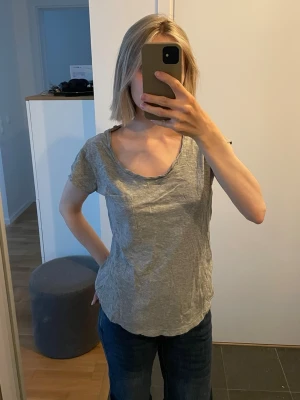 Grå basic t-shirt med v-ringning - Enkel grå t-shirt i storlek XS med avslappnad passform och djup v-ringning. 10 kr!