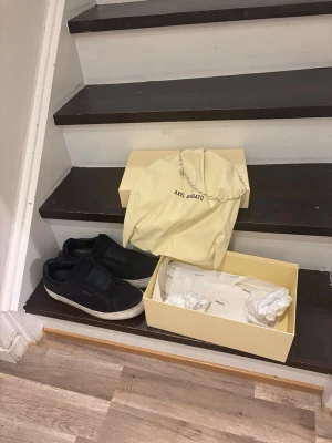 Svarta slip-on sneakers Axel Arigato - Stilrena mörkblåa slip-on sneakers från Axel Arigato i mocka med vit sula. Diskret logga på sidan och elastiska band över vristen för enkel påtagning. Kommer med originalkartong och dustbag. Priset kan diskuteras vid snabbaffär!