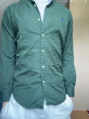 Grön skjorta från Ralph Lauren  - Säljer denna Polo Ralph Lauren skjortan i storlek Xs. Modellen är 175 väger 65kg och har storlek S. Skriv vid frågor  Längd 66cm  Bredd 45cm  Armlängd 60cm
