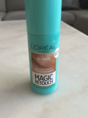 L'Oréal Magic Retouch Blonde spray - Ljusblå sprayflaska med L'Oréal Magic Retouch för blont hår. Perfekt för att snabbt täcka utväxten mellan färgningar. Enkel att använda och ger ett naturligt resultat. Smidig storlek att ta med i väskan. Endast testad.