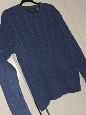 Marinblå Kabelstickad tröja Polo Ralph Lauren - Nytt skick, använd 1 gång. Snygg blå kabelstickad tröja från Polo Ralph Lauren. Nypris: 2 895 :-