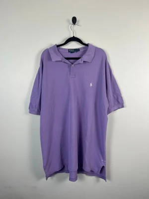Vintage Polo Ralph Lauren Piké XXL Lila Lavender 100% Cotton Retro Y2K HerrVintage Polo Ralph Lauren Piké XXL Lila Lavender 100% Cotton Retro Y2K Herr - • Storlek: XXL • Färg: Ljuslila • Passform: Classic Fit  • Krage: Klassisk ribbad pikékrage • Material: 100% bomull  Skick: Plagget är i väldigt fint skick. Eventuella anmärkningar anges alltid tydligt i beskrivningen och visas på bilderna.  Nypris: Cirka 1 400 kr.  📦 Skickas snabbt och packas omsorgsfullt. 💬 Hör gärna av dig om du har frågor eller vill se fler bilder. 🤝 Samfrakt erbjuds vid köp av flera plagg – kika gärna in mina andra annonser!• Storlek: XXL • Färg: Ljuslila • Passform: Classi