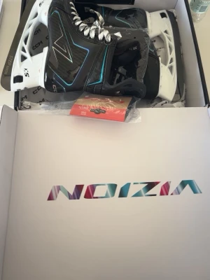 CCM VIZION - Säljer ett par svarta hockeyskridskor från CCM med vita detaljer och vita snören. Skridskorna har coola blå och silverfärgade linjer och robusta vita hållare. Perfekta för isträning eller match. Levereras i originalkartong. Storlek 7 regular fit. Passar fötter som använder 41-42. Helt nya använda en gång men va för stora allt medföljer