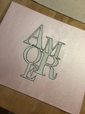 Rosa tavla - Säljer en stilren tavla med ordet AMORE. Bakgrunden är ljusrosa med shimmer med svart kontur. Perfekt som dekoration till sovrum. Målningen är gjord på canvas och har en modern, enkel design. Bara att höra av sig vid frågor eller mått💞 köparen står för frakten💞