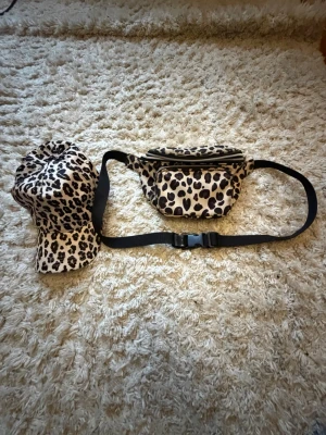 Leopardmönstrad keps - Snygg keps med leopardmönster i beige, svart och brunt. Klassisk böjd skärm och justerbar passform bak. Perfekt för dig som vill sticka ut med en trendig accessoar.