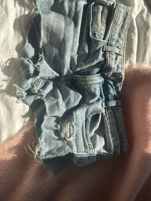 Ljusblå slitna jeansshorts - Säljer ett par ljusblå  jeansshorts från hm! Sypersnygga!