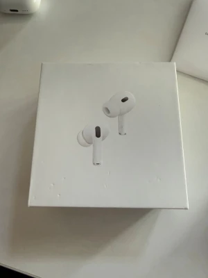 Airpods  - Säljer ett par vita trådlösa in-ear hörlurar med laddningsetui. Hörlurarna har en stilren och kompakt design och levereras i originalförpackning. Perfekta för musik, poddar och samtal på språng. Möts bara upp bor i Västerås