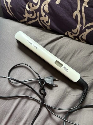 Remington Shine Therapy plattång - Plattång från Remington i modellen Shine Therapy. Färgen är vit med svart insida och digital display. Sladd med EU-kontakt. Perfekt för att styla håret och få extra glans. Ergonomisk och smidig design som är enkel att använda.