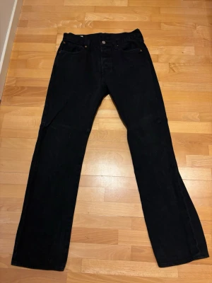 Levis 501 svart - Hej, säljer nu dessa svarta Levis 501 jeans i storlek 32/32. Inprincip nyskick och passar mig ganska bra som cirka 1,81 och väger cirka 70kg, kanske en aning stora i midjan bara. Tveka ej på att skicka iväg en fråga och pris ej hugget i sten!