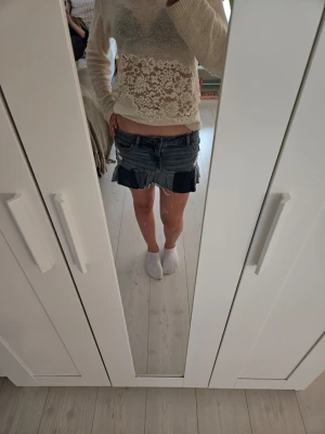 Blå jeanskjol med volangkant - Säljer en kort jeanskjol i blå denim med råa kanter och en snygg volangdetalj längst ner. Kjolen har klassiska fickor fram och bak. Hör av er för fler frågor.